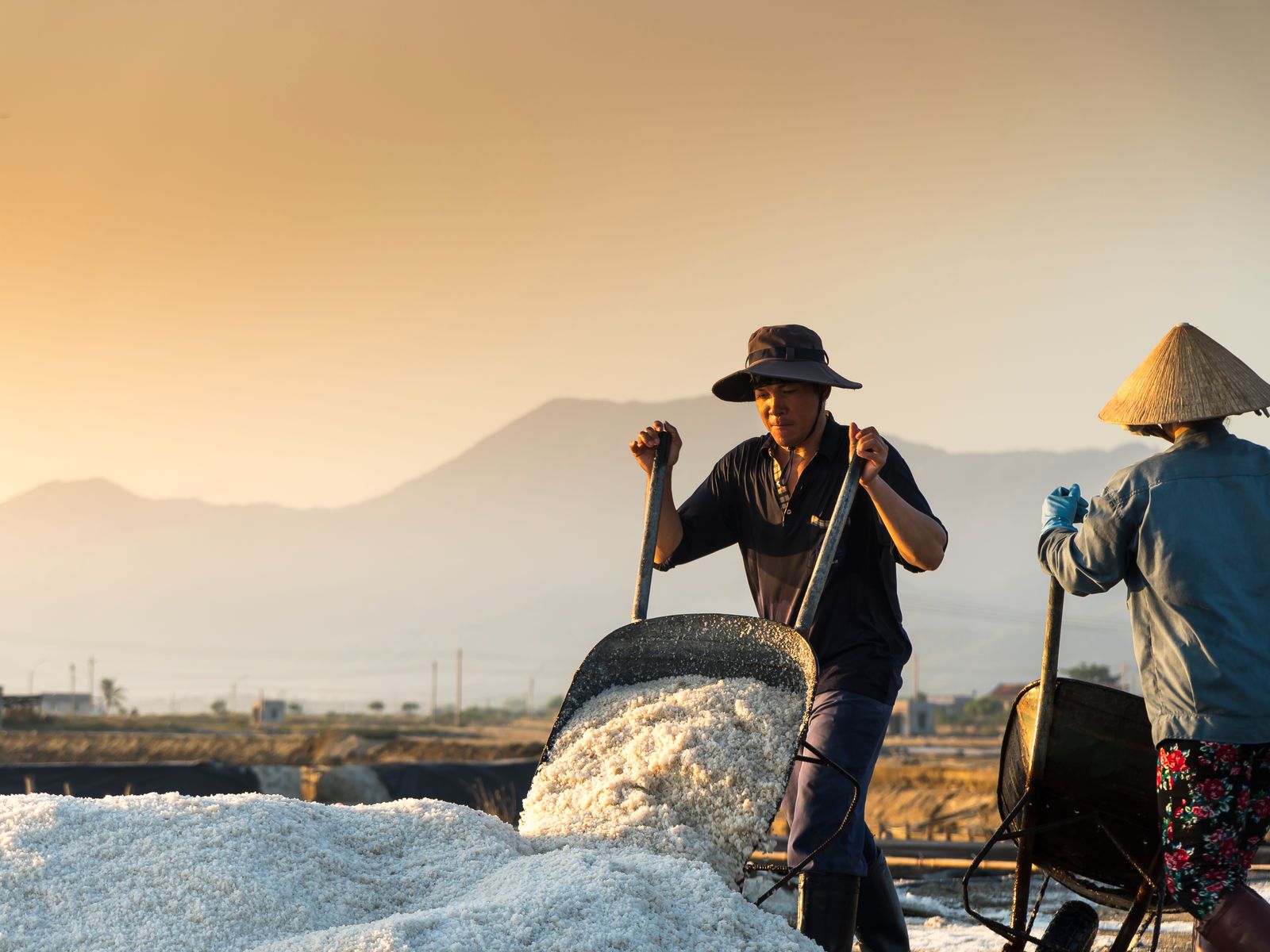 Salt makers gathering the day's harvest at dusk