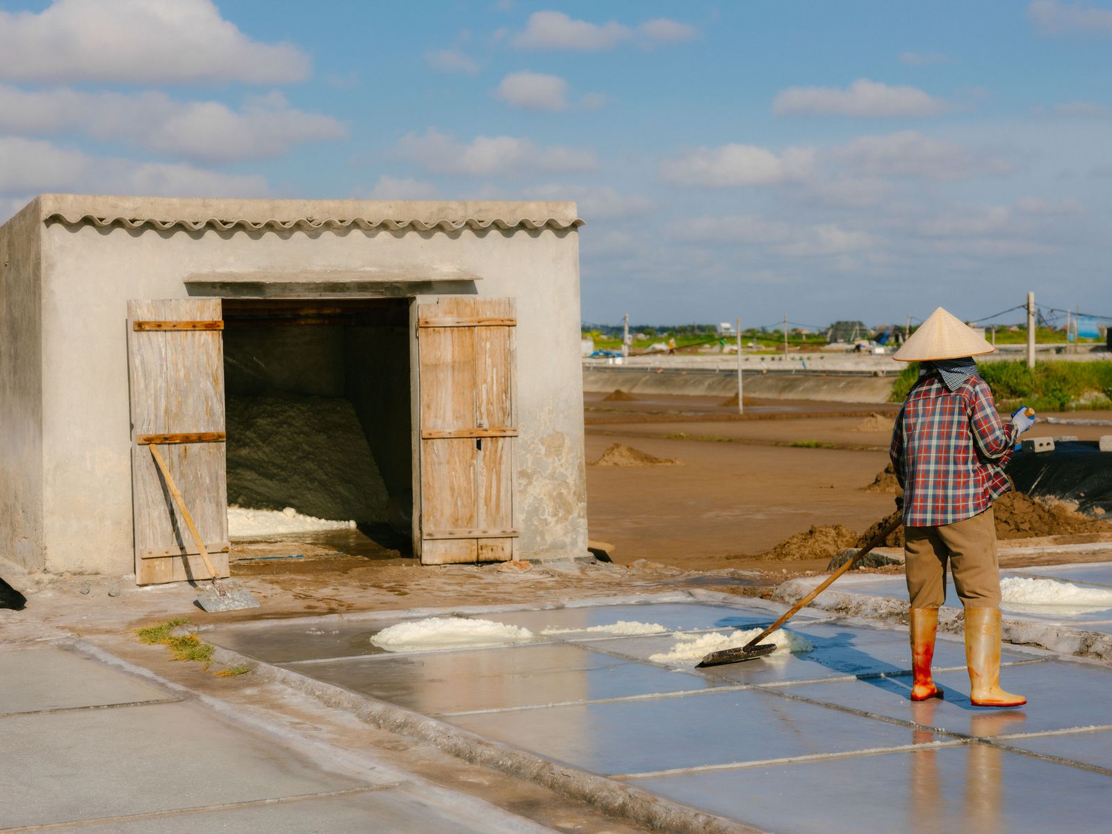 A salt farmer at work on the pans
