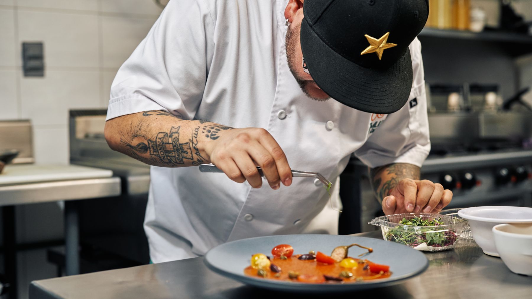 A chef finishing a dish with flaked sea salt