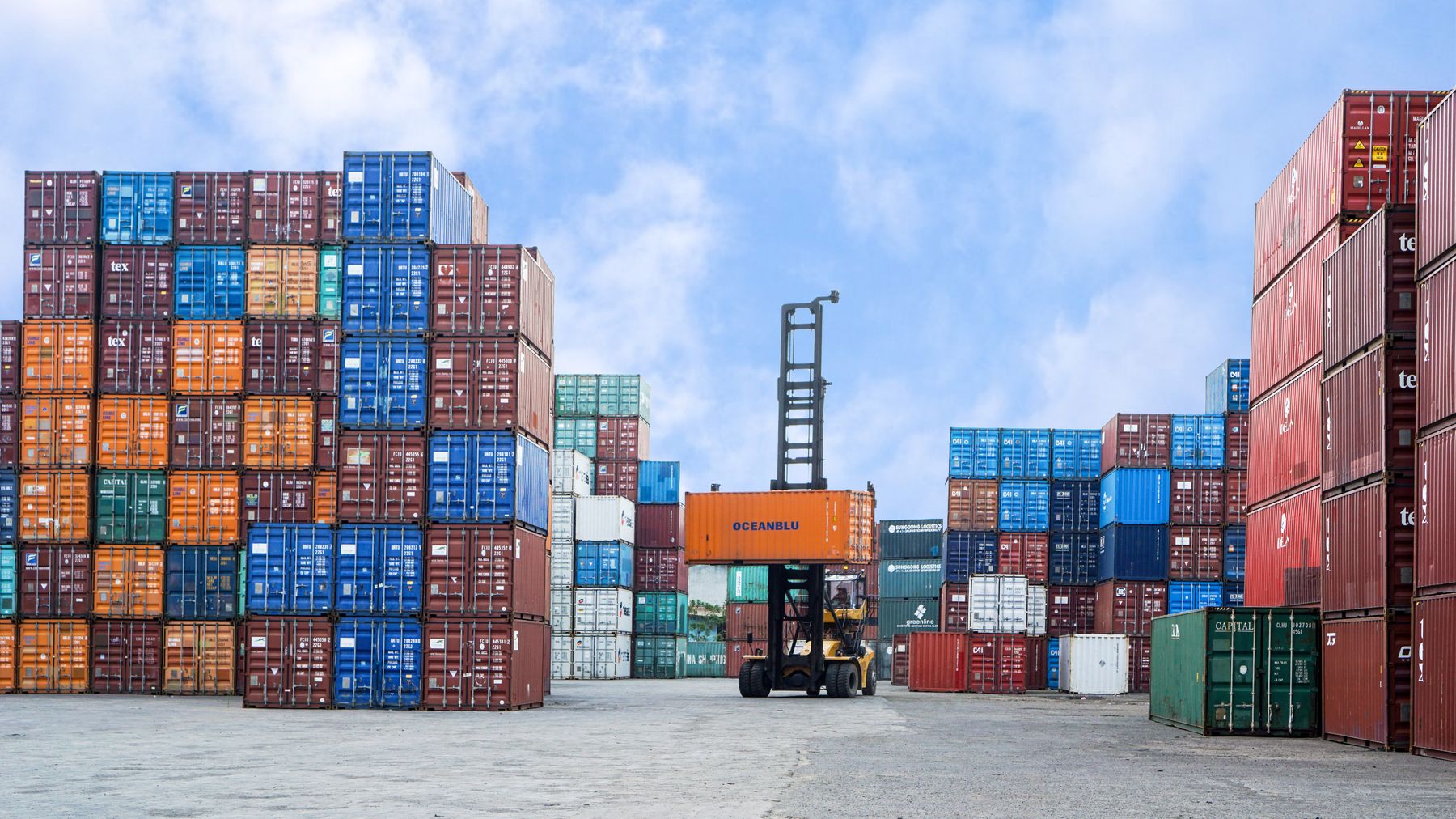 Containers and forklift at an Indonesian export port