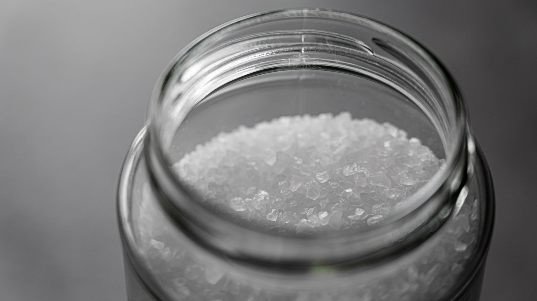 Sea salt crystals in an open glass jar