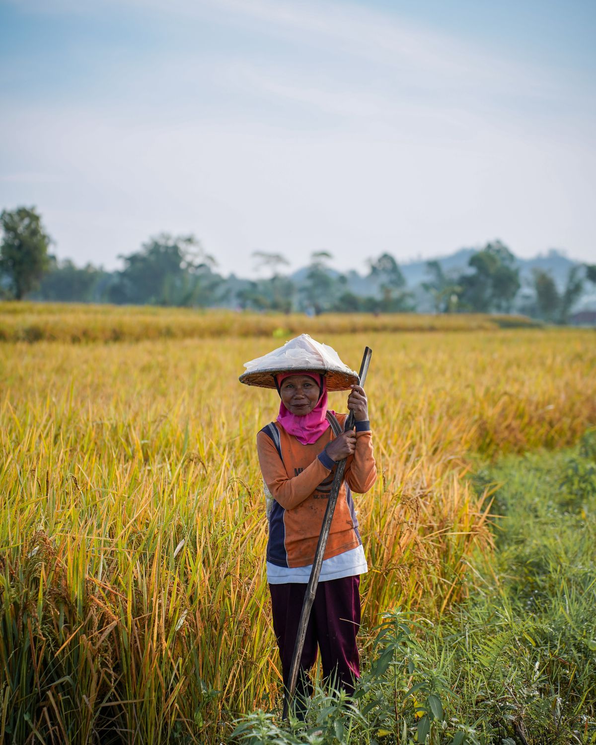 A Balinese salt farmer in a conical hat