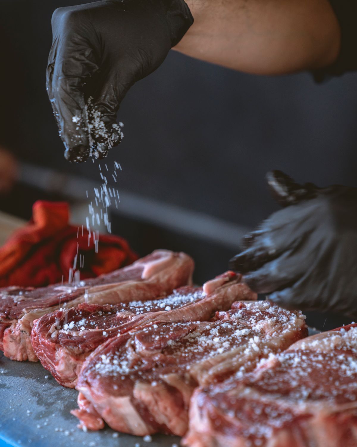 A chef seasoning with sea salt before the grill